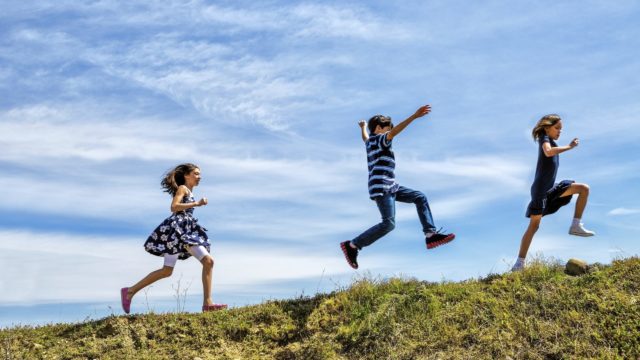 Children Running and Jumping up a hill