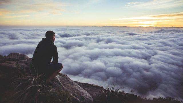 Man on mountain looking forward