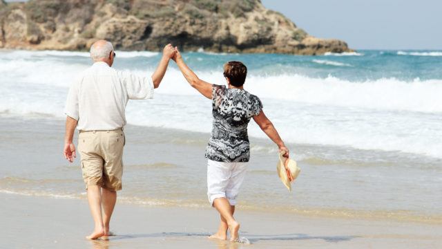 Senior couple walking on the beach together