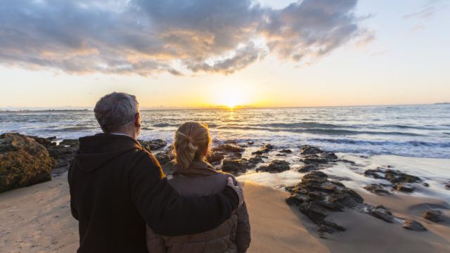 Couple on the beach looking out to sea