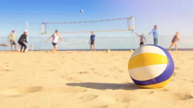 Group of friends playing beach volleyball