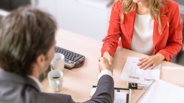 Male and female business people shaking hands