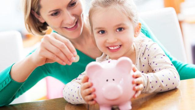 Mother and daughter with piggy bank