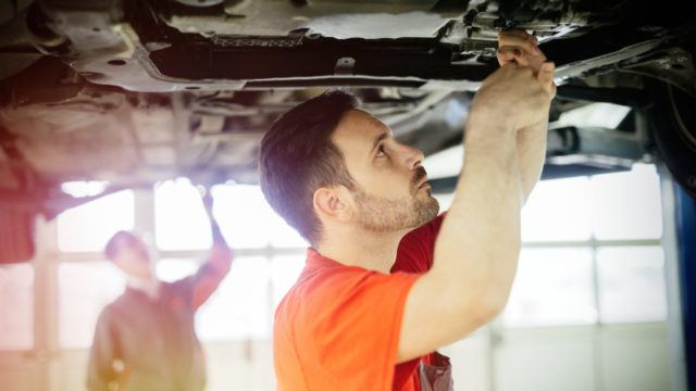 Car mechanics working and maintaining car