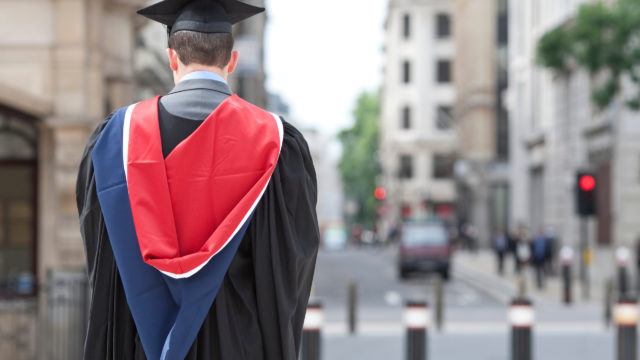 university graduate standing on London street