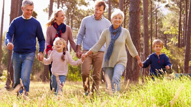 A happy multi-generational family walking through the countryside