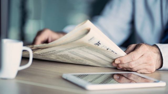 businessman reading newspaper on table