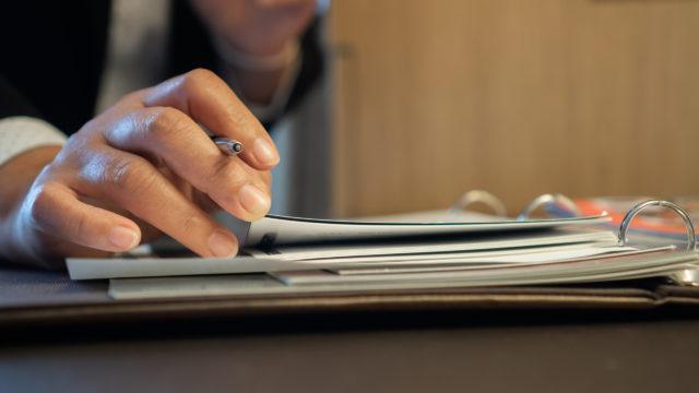 person signing document in binder file