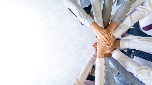 office workers doing “hands in”