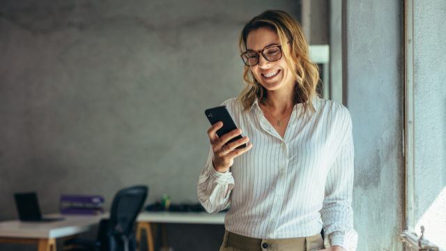 businesswoman smiling looking at her phone