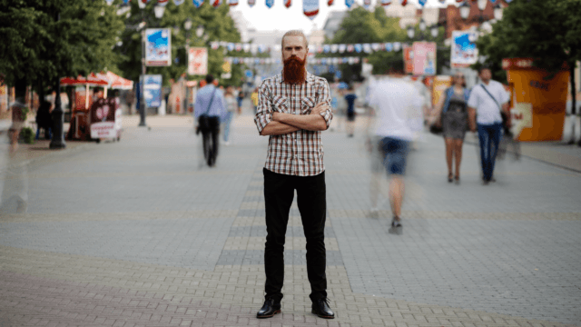 man standing still while everyone moves quickly around him