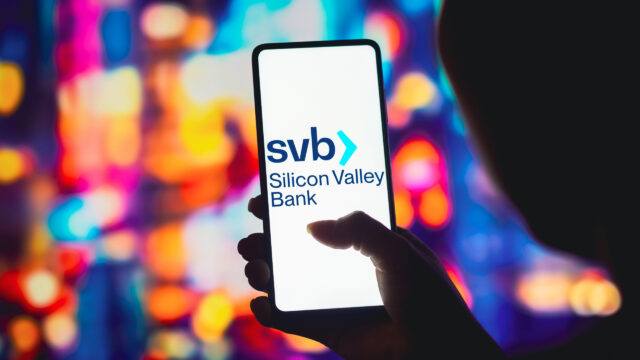 person holding smartphone with SVB logo displayed
