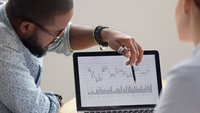 analyst sowing a graph on a laptop screen