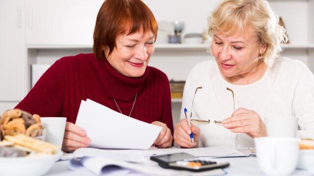 two women looking at bills