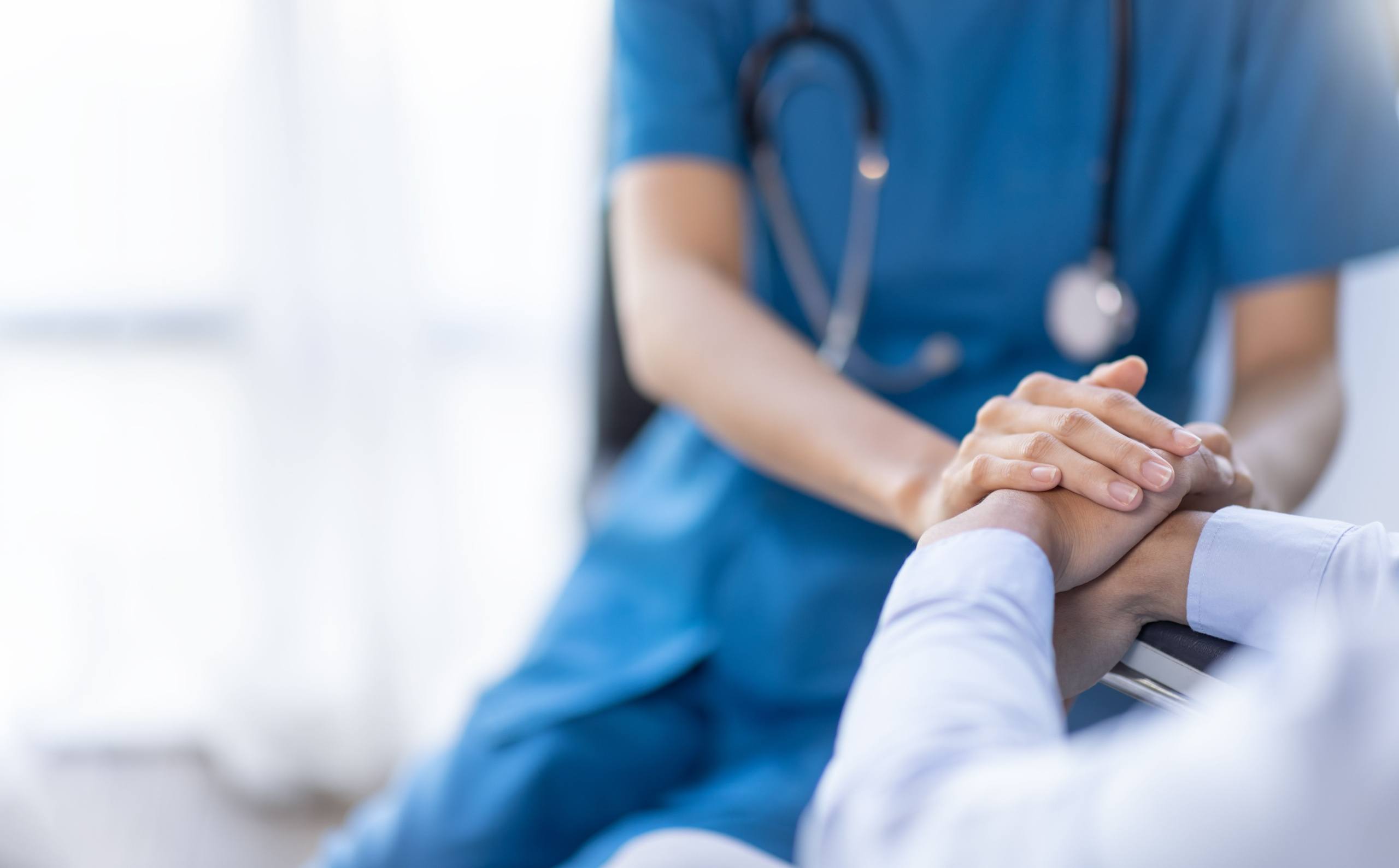 Nurse holding a patient’s hand